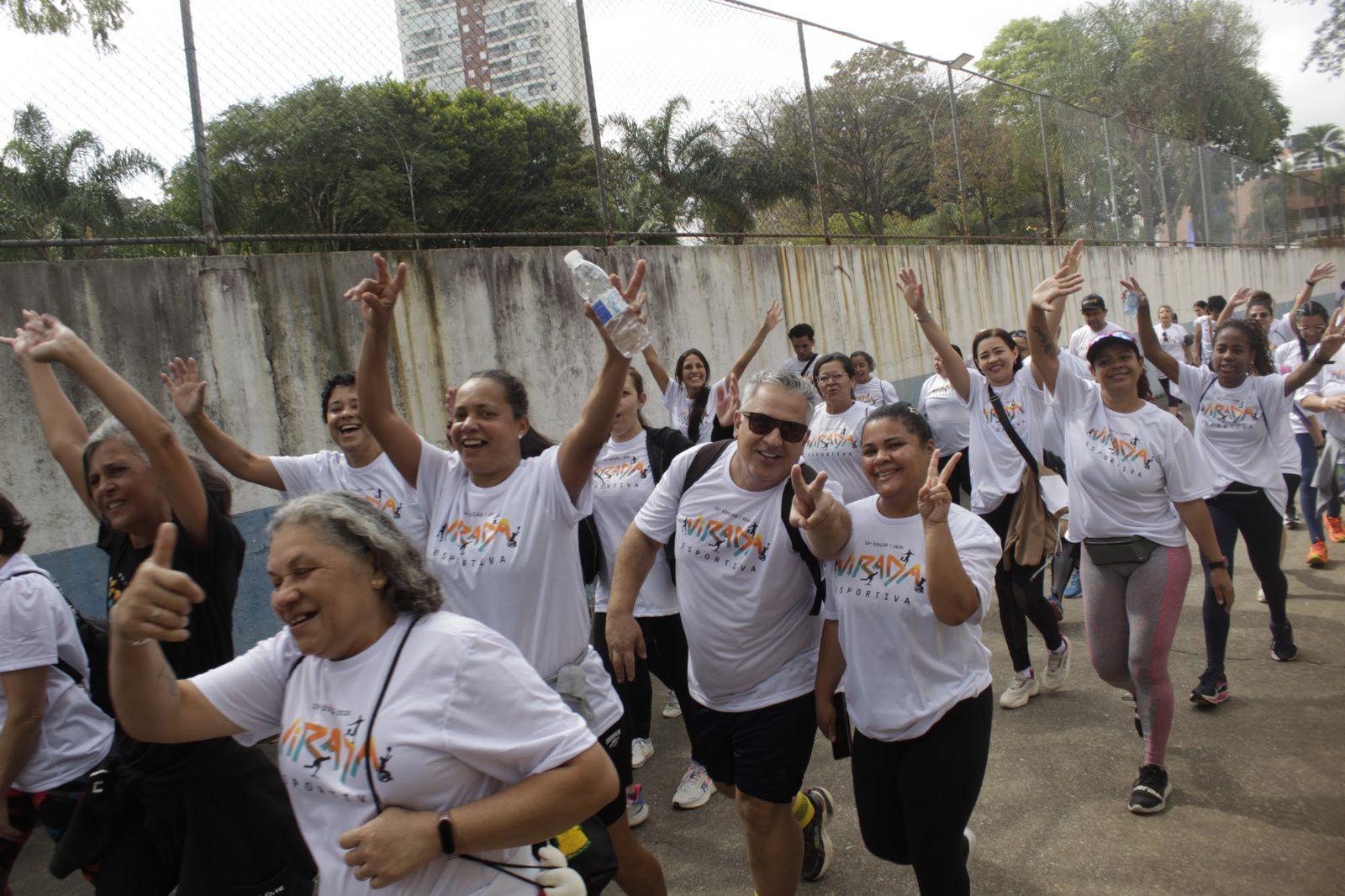 Participantes acenando durante a caminhada