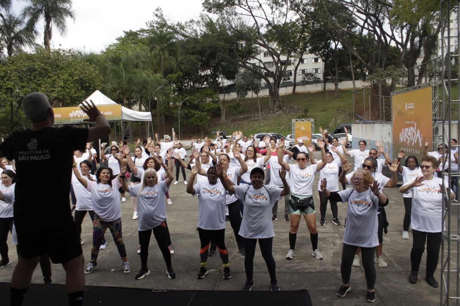Participantes dançando com os braços para o alto